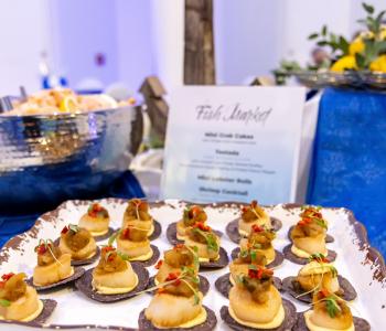 Tostada bites topped with scallop, chutney and pepper, presented at a Fish Market themed table. Photo by Bellini Studios.