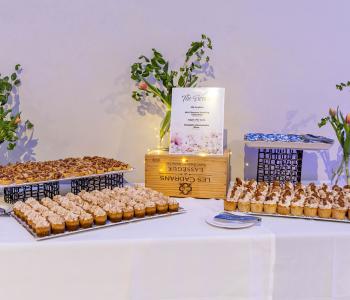Apple pie tarts, mini banana pudding cupcakes, UB cut out cookies, and pumpkin cheesecake bites presented at a dessert table. Photo by Bellini Studios.
